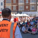 A man standing wearing a event safety suit