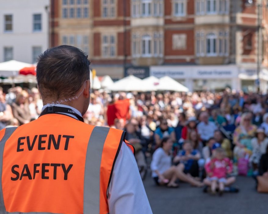 A man standing wearing a event safety suit