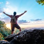 rear-view-back-young-asian-hiking-man-standing-riseup-hands-with-happy-peak-rocky-mountain