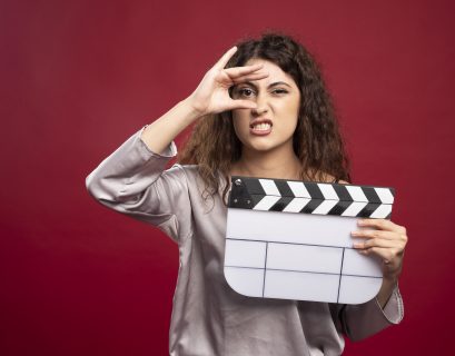 A women holding a clapperboard making faces