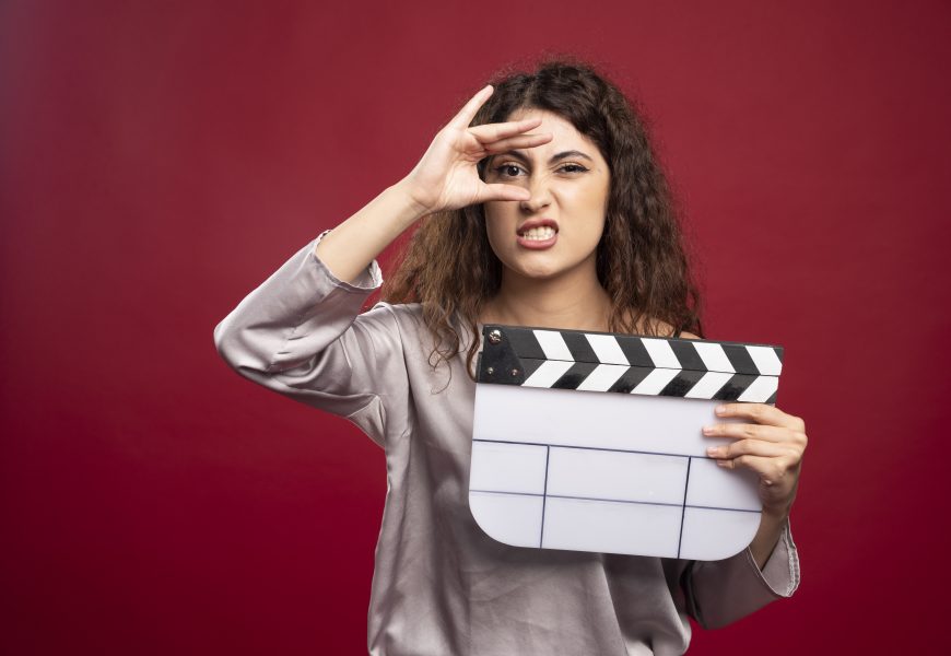A women holding a clapperboard making faces