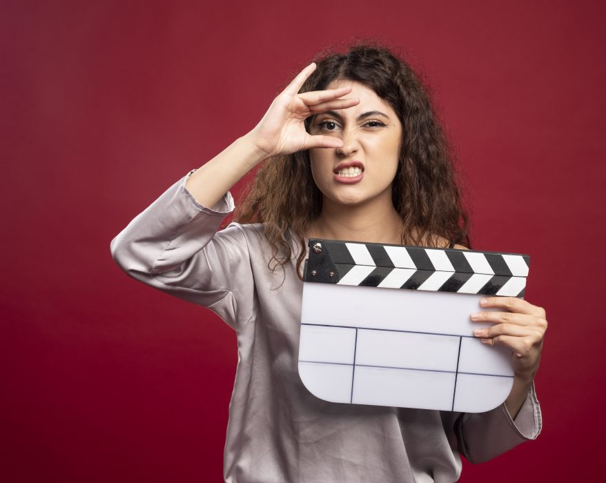 A women holding a clapperboard making faces